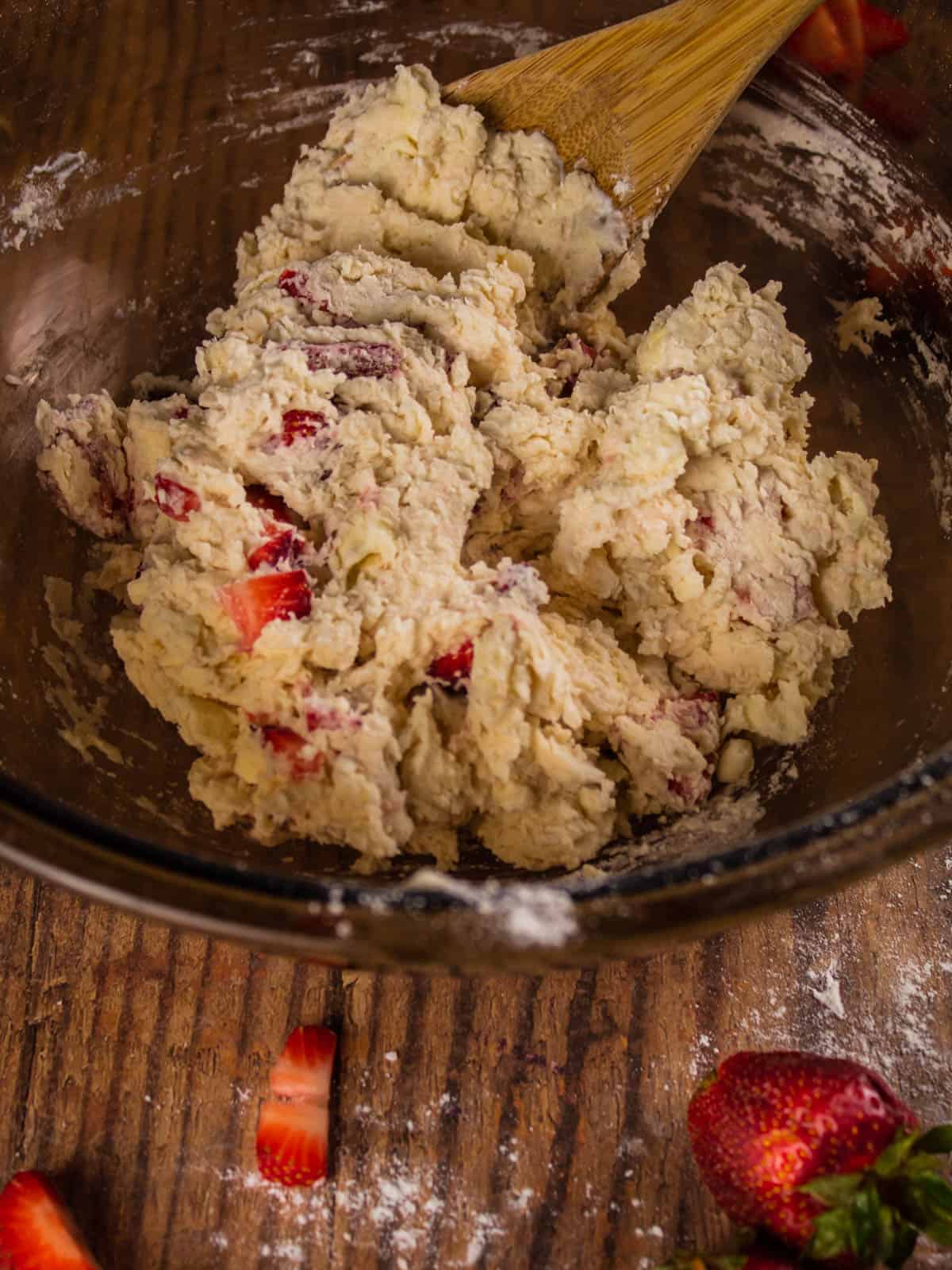 mixed biscuit dough with strawberries in a bowl