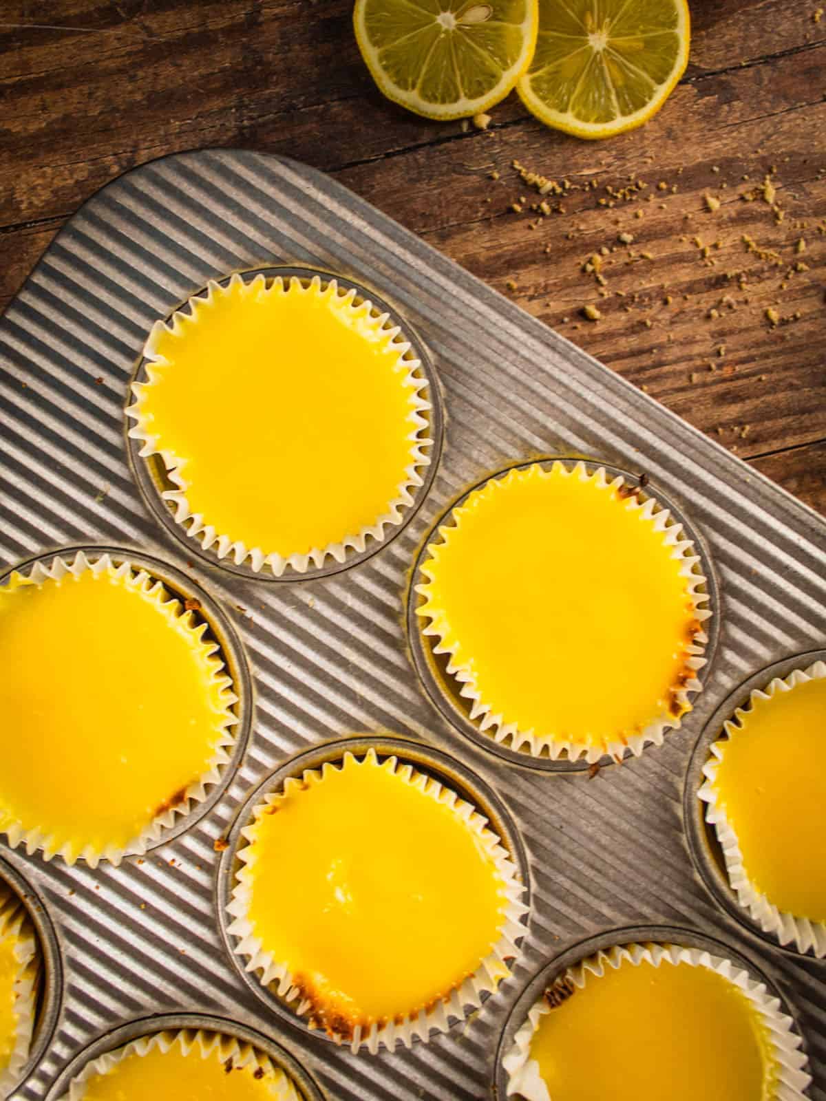 mini cheesecakes topped with lemon curd in a muffin pan