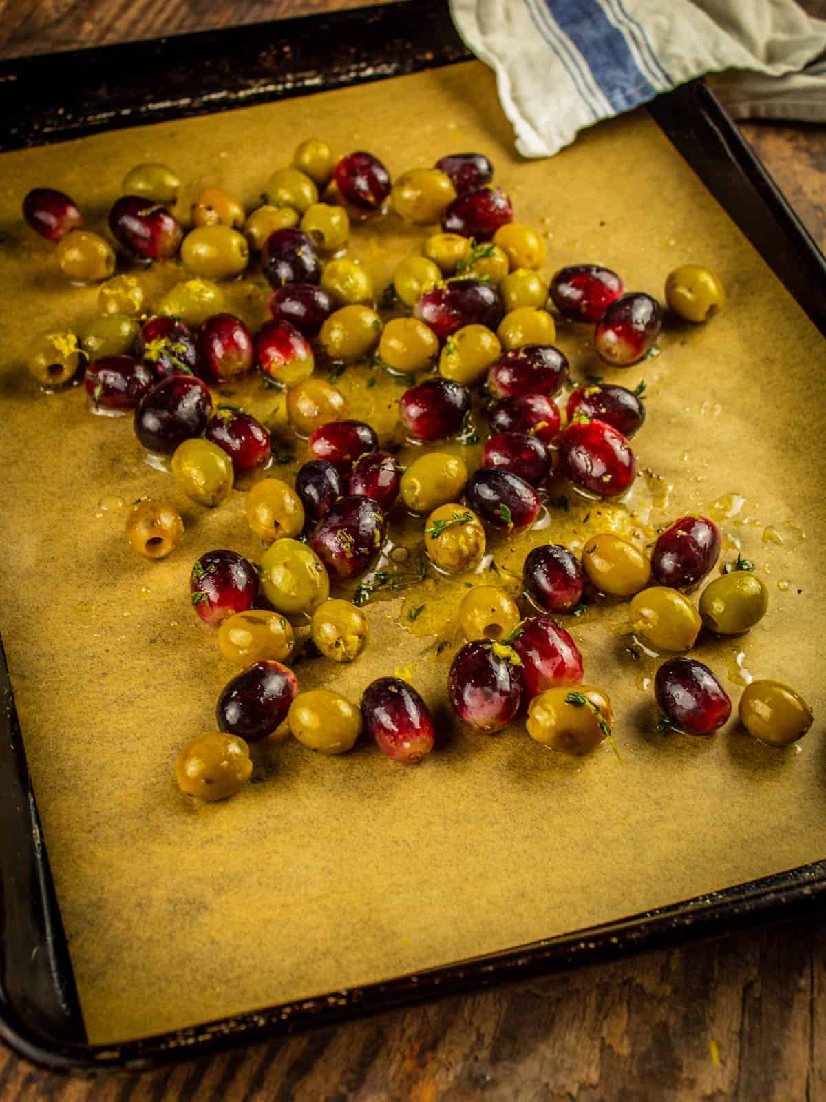 seasoned red grapes and green olives on a sheet pan