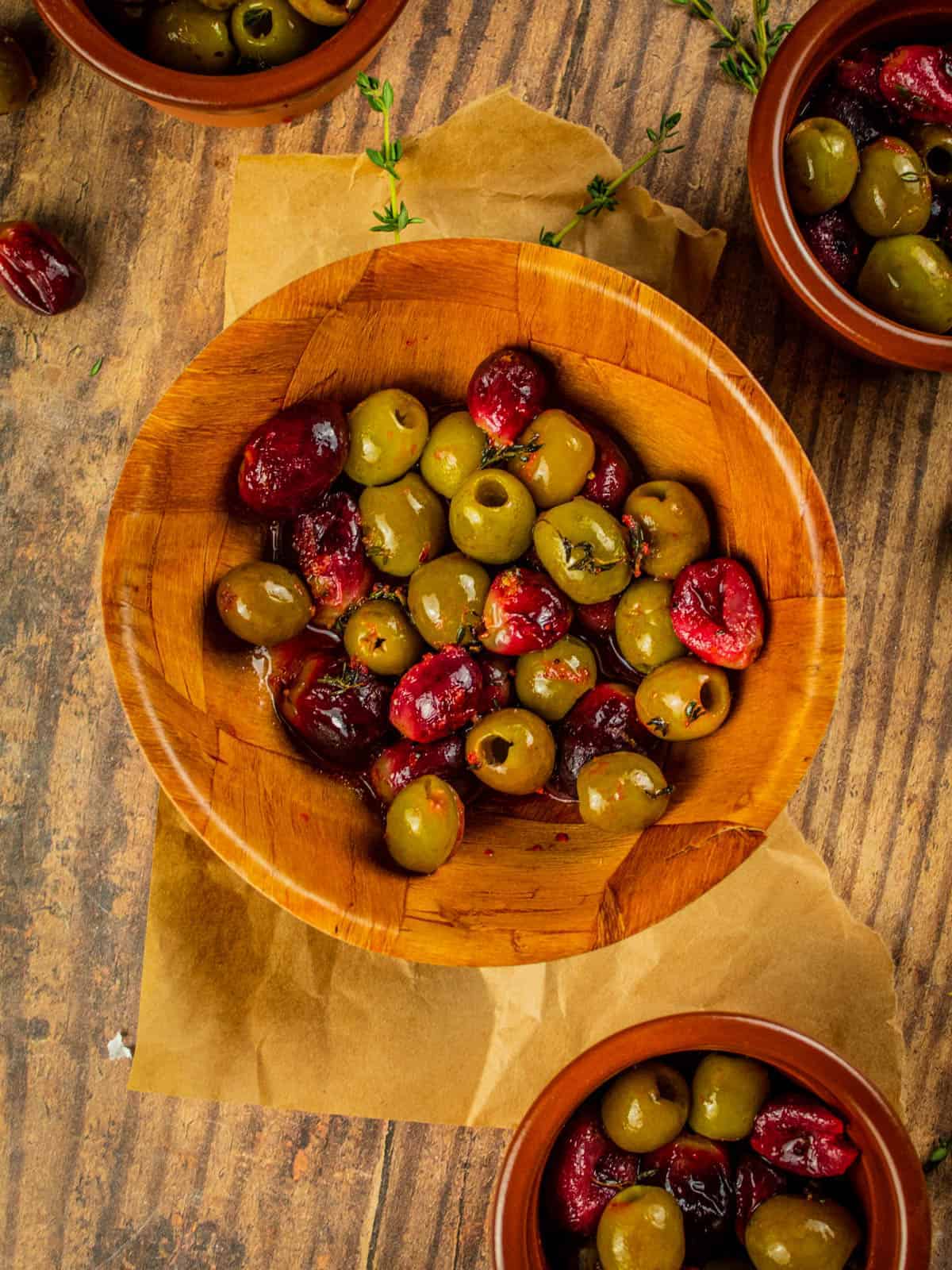 small brown dishes with red grapes and green olives that have been roasted