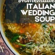bowl of italian wedding soup with spinach with grated cheese on top.