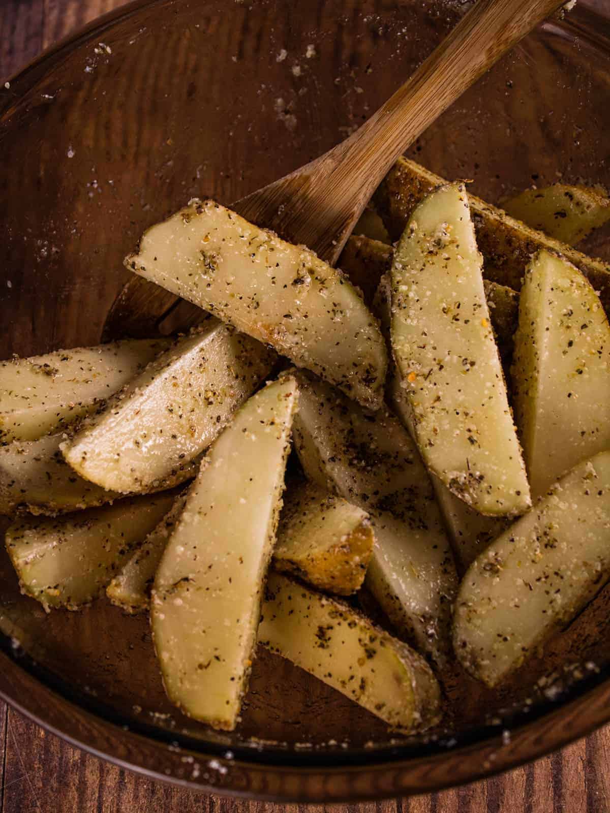 seasoned potato wedges in a mixing bowl