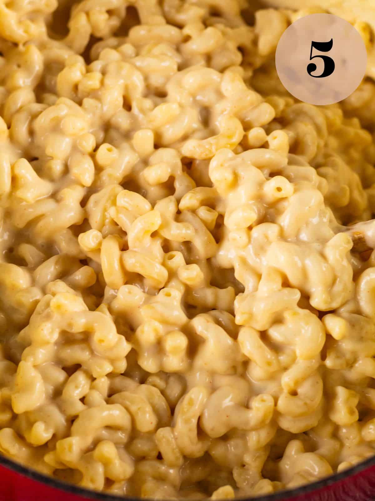 close up shot of creamy white mac and cheese in a pot.