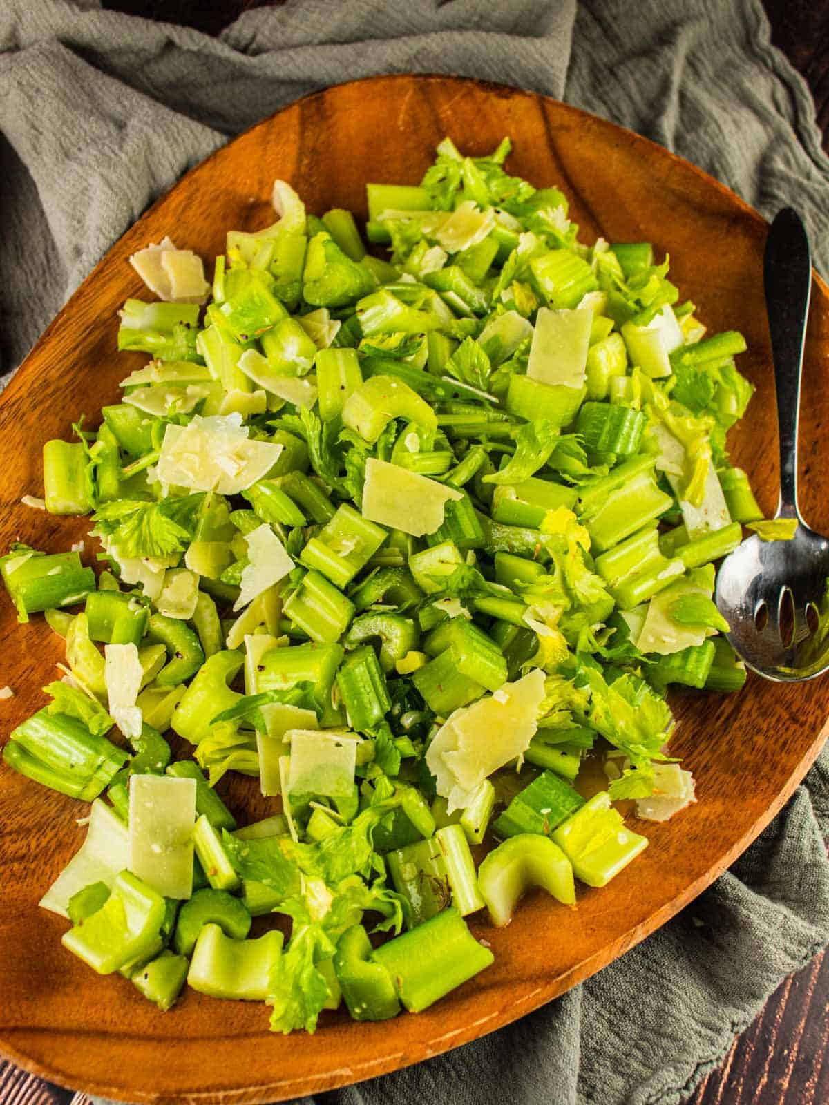 italian celery salad on a wooden tray with a metal spoon.