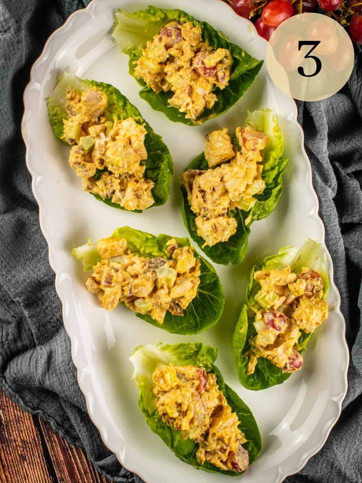 curry chicken salad on lettuce cups on a white oval platter