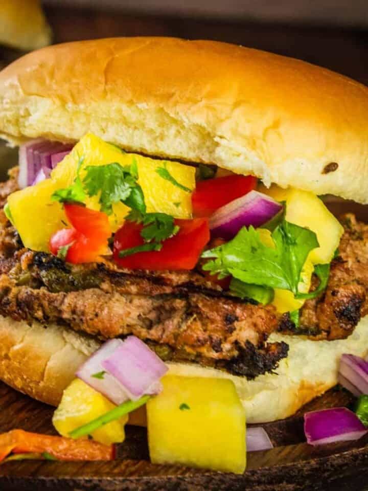grilled turkey burgers on a bun topped with fresh pineapple salsa
