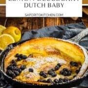 baked dutch baby pancake in a cast iron skillet with blueberries and powdered sugar