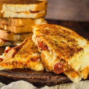 pepperoni pizza grilled cheese cut in half and stacked on each other
