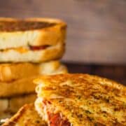 pizza grilled cheese with pepperoni cut in half and stacked on each other.