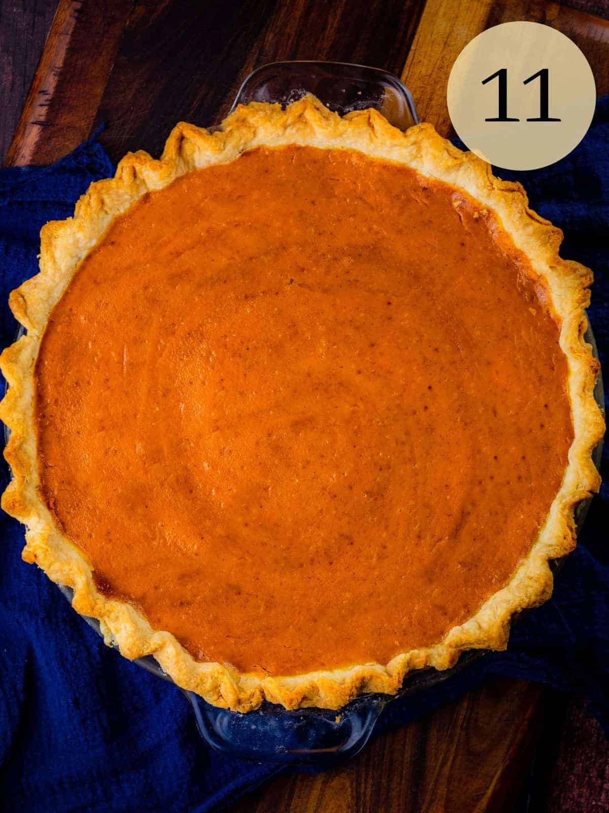 freshly baked homemade pumpkin pie with crimped pie crust on a blue napkin