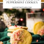 cookies dipped in white chocolate with peppermint candies stacked in front of lights