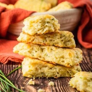 fluffy rectangle shaped biscuits stacked on top of each other next to a bunch of fresh chives
