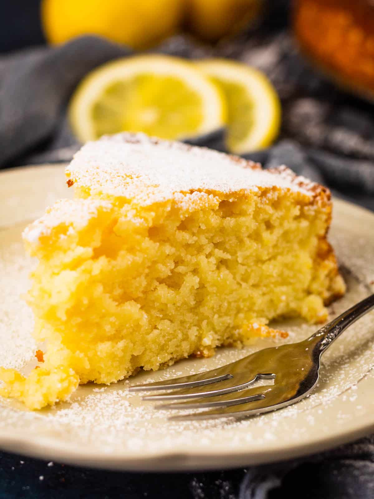 slice of italian ricotta cake with lemon on a plate with a fork.