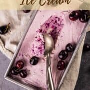 ice cream scoop with black cherry ice cream and fresh cherries.