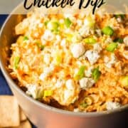 bowl of buffalo chicken dip topped with green onions and blue cheese.