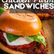 fried chicken parm sandwich with cheese, sauce and basil.