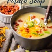 bowl of loaded potato soup with bacon, sour cream, green onions and cheddar cheese.