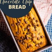 baked pumpkin chocolate chip bread in a pan on a cooling rack.