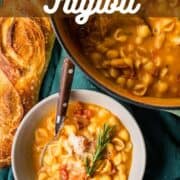 pot and bowl of italian pasta fagioli soup with a loaf of bread.