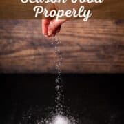 hand sprinkling salt onto a table.