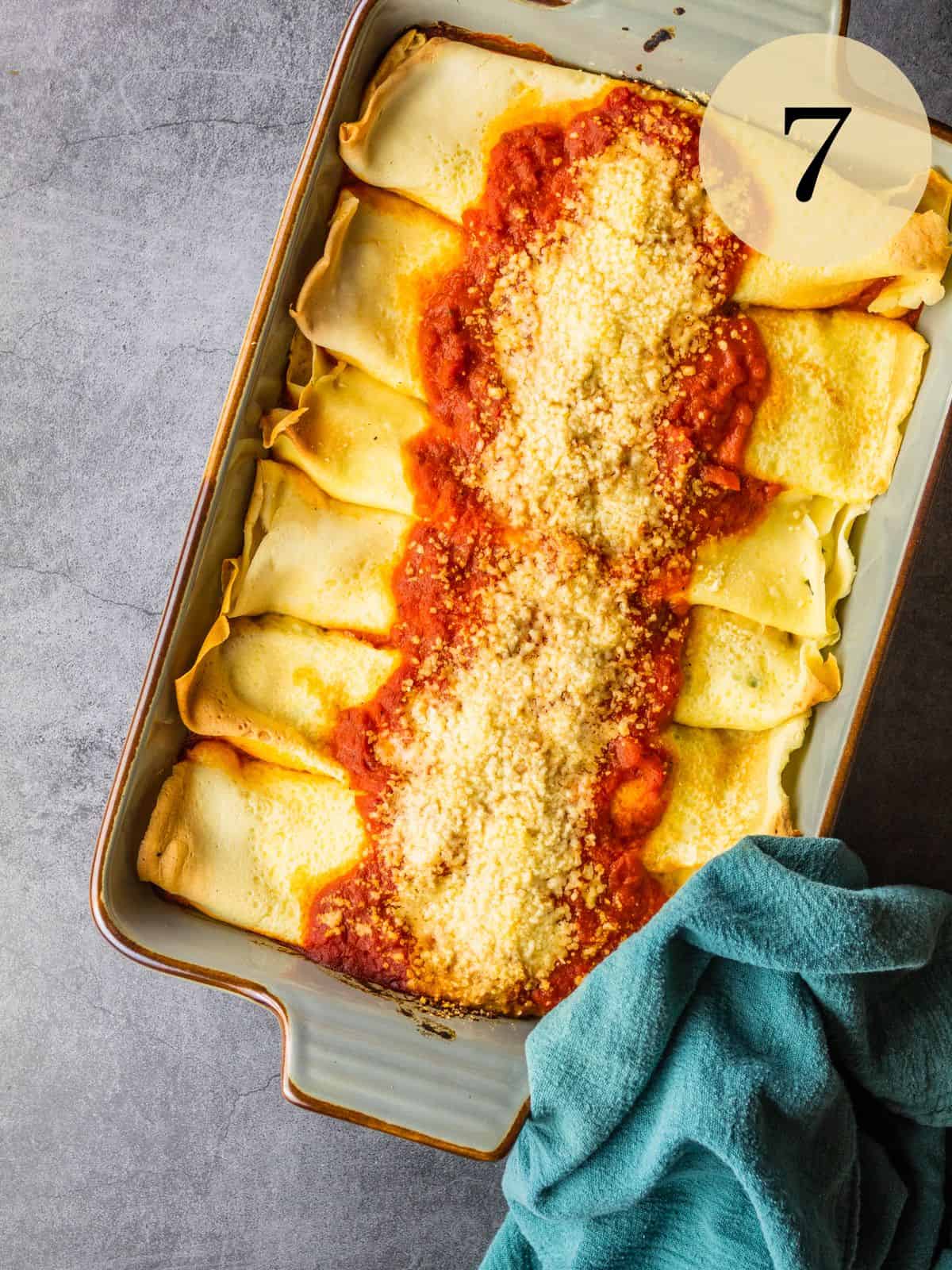 baked manicotti in a baking dish next to a green linen napkin.