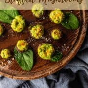 wooden tray of spinach and cheese stuffed mushrooms.