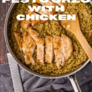 skillet filled with orzo with pesto sauce and sliced chicken on top with grated cheese.