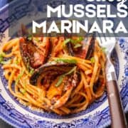 mussels with marinara in liguine in a bowl with a fork.