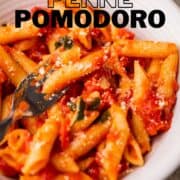 bowl of penne pomodoro with basil.