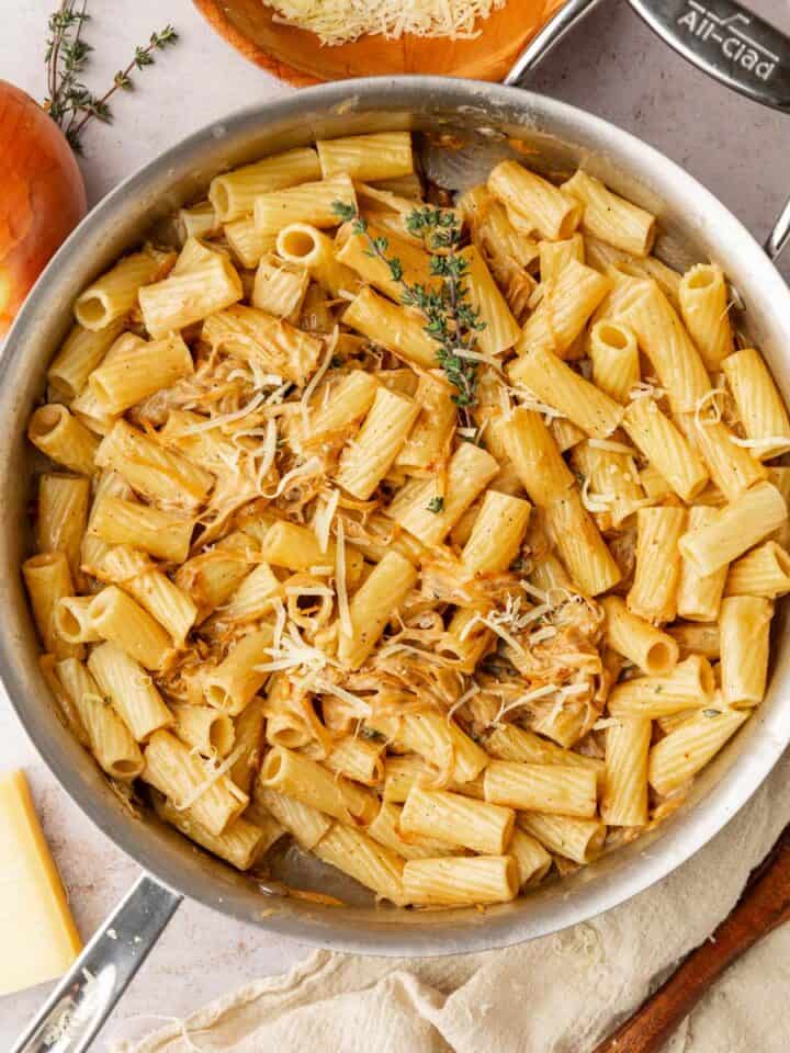 french onion rigatoni pasta with fresh thyme garnish in a skillet.