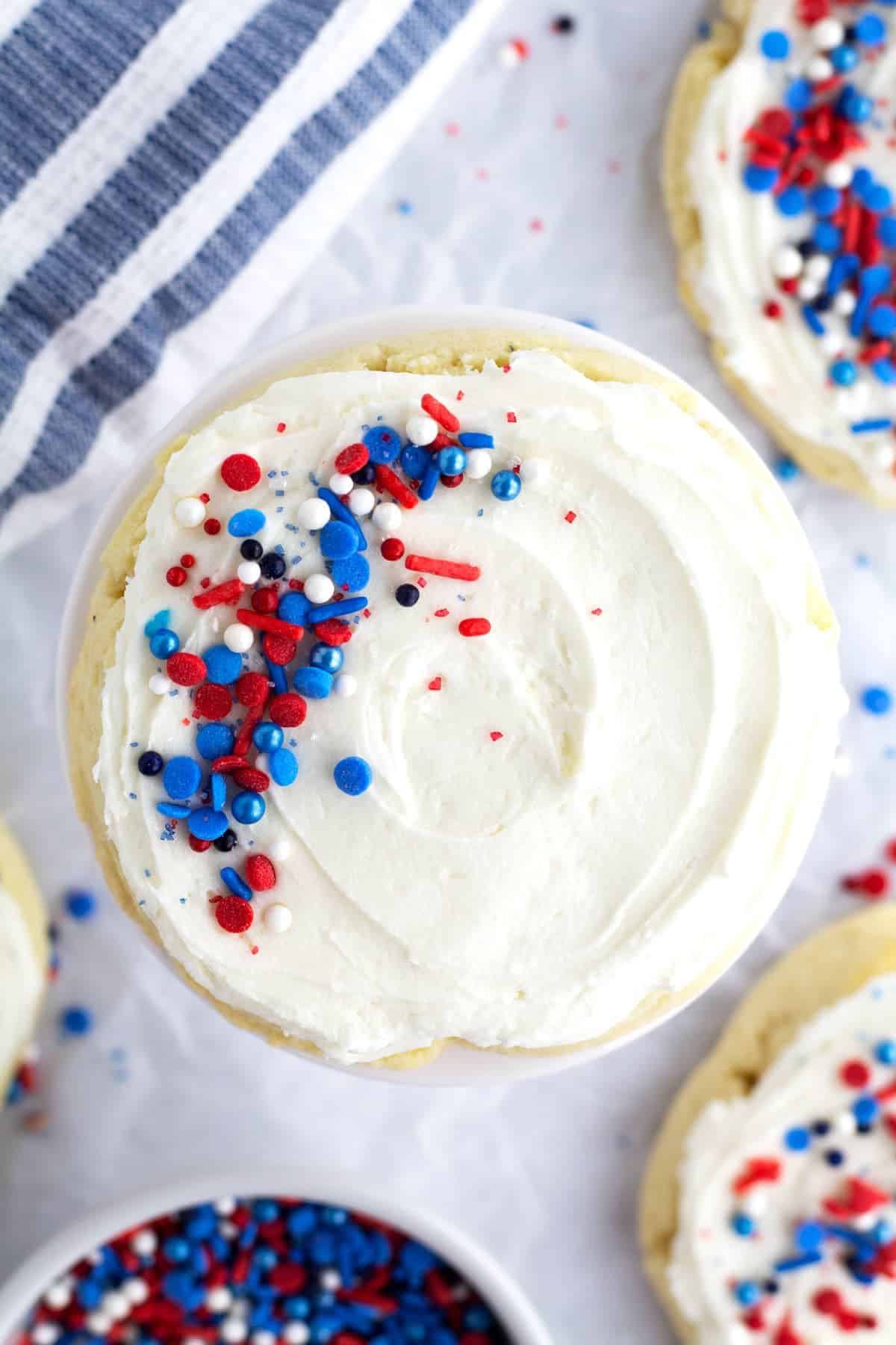 sugar cookie topped with white frosting and red, white and blue sprinkles.