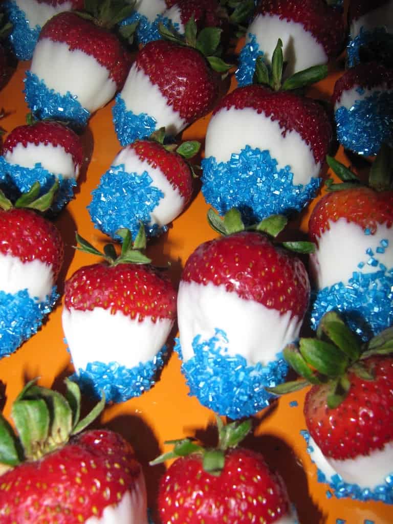 strawberries dipped in white chocolate and then in blue sprinkles.