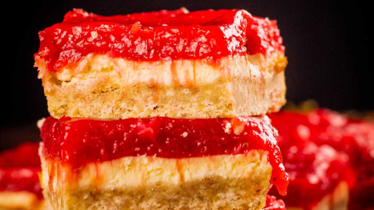 strawberry rhubarb cheesecake bars stacked on top of each other.