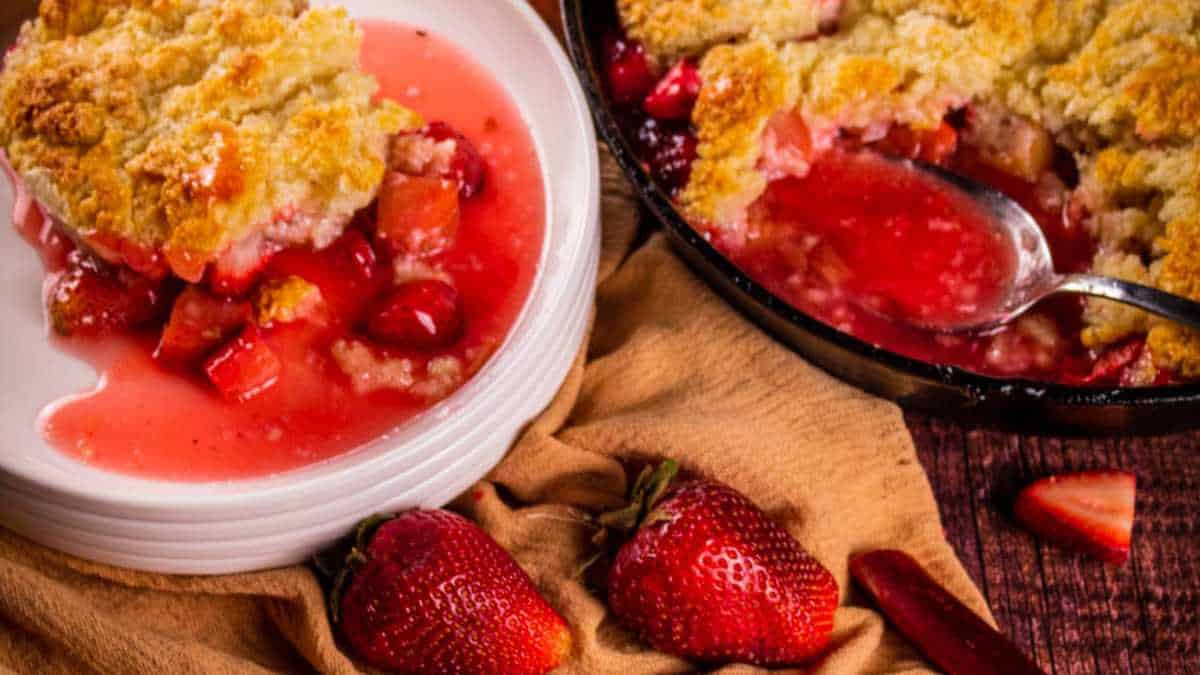 strawberry rhubarb cobbler in a cast iron skillet and on a plate.