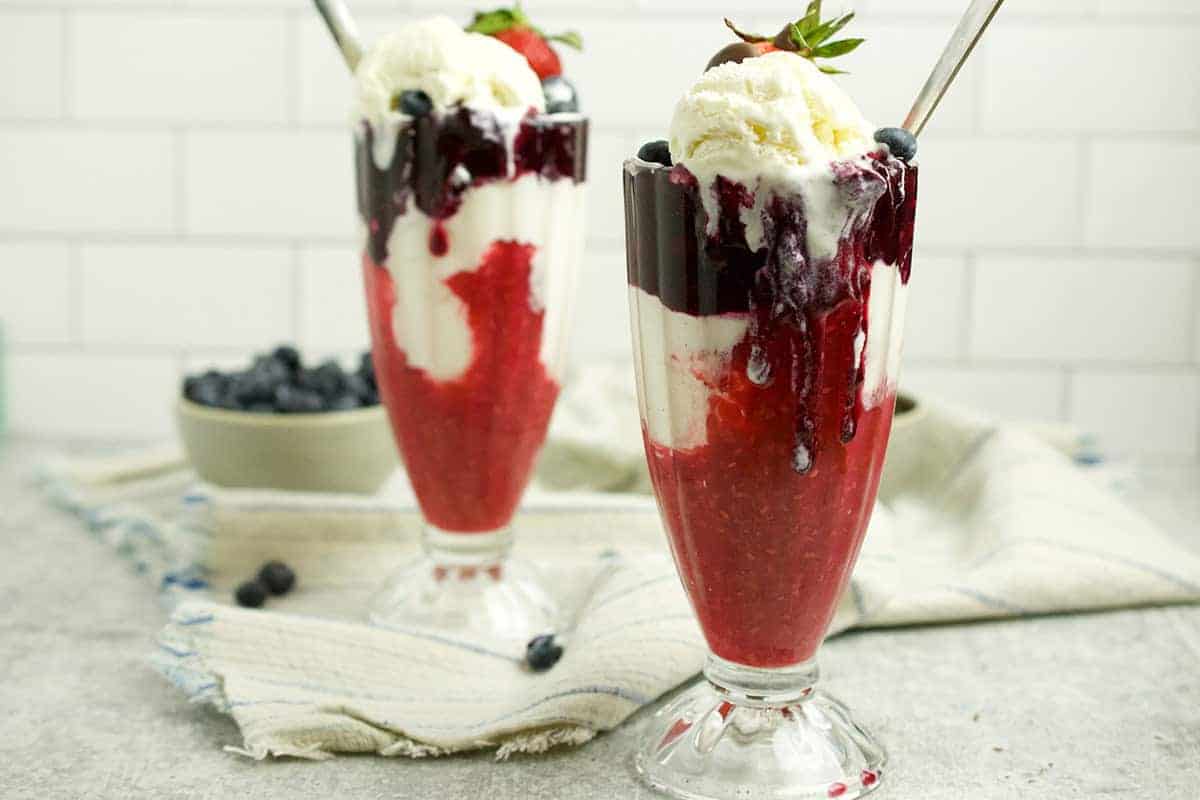 red white and blue layered sundaes in ice cream sundae glasses.