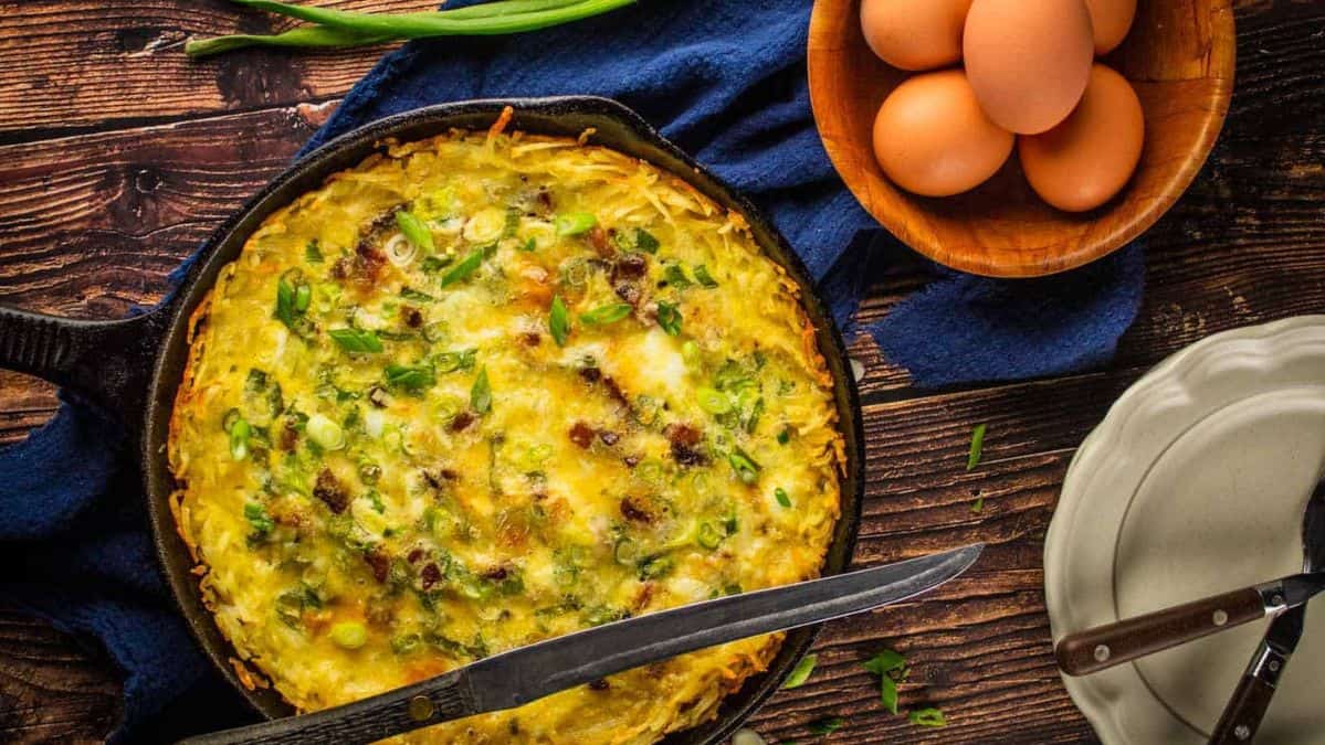 quiche with scallions and pancetta in a cast iron skillet.