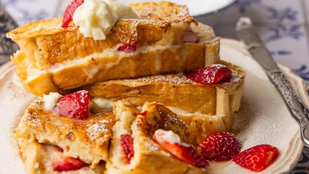 stuffed french toast with mascarpone frosting and sliced strawberries.