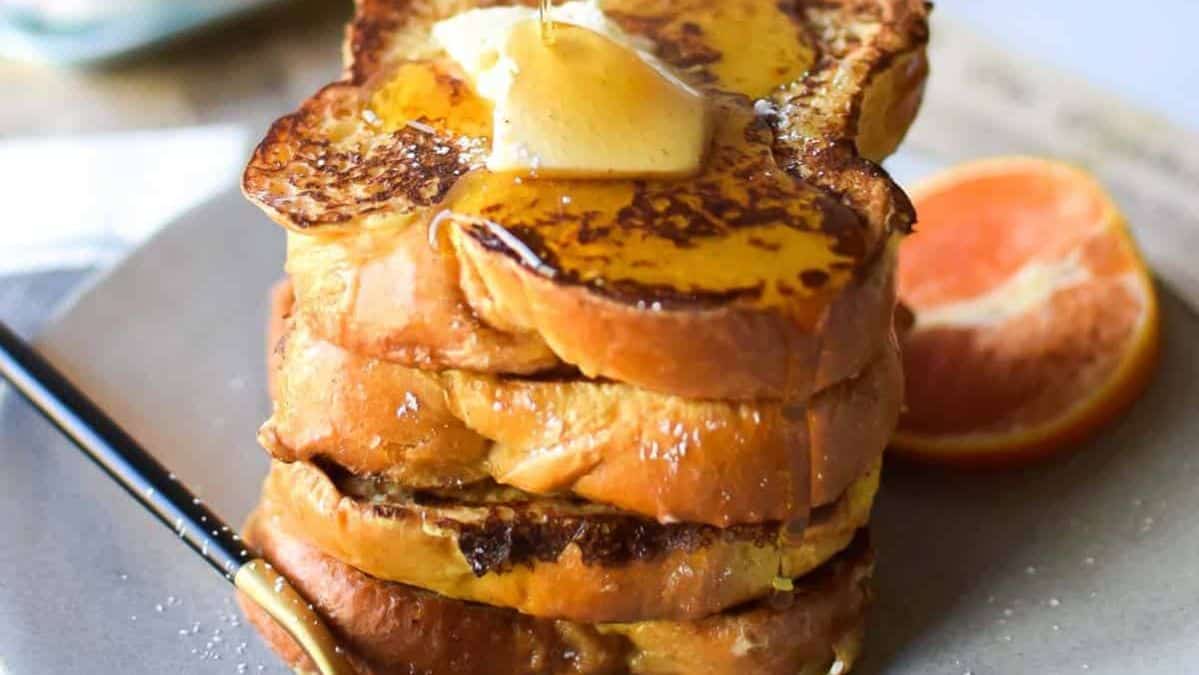 stack of french toast topped with butter and syrup.