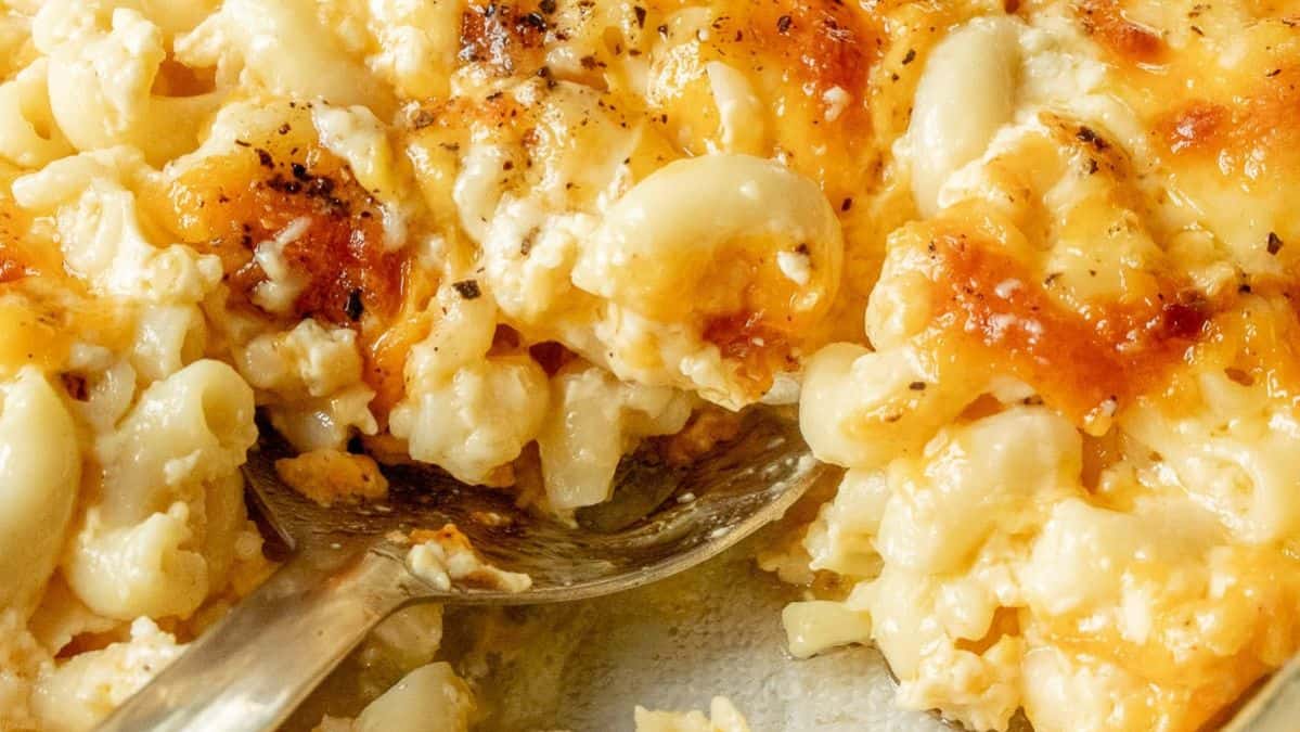 spoon scooping into baked macaroni and cheese.