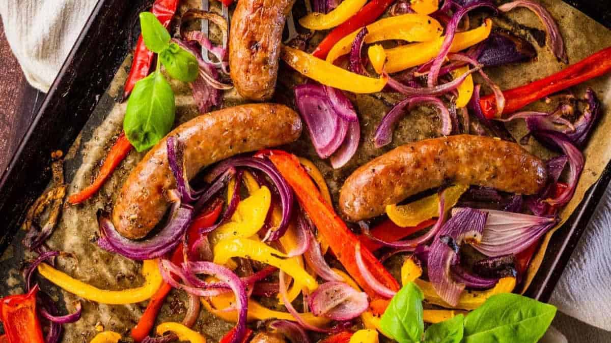 sausage peppers and onions baked on a sheet pan.