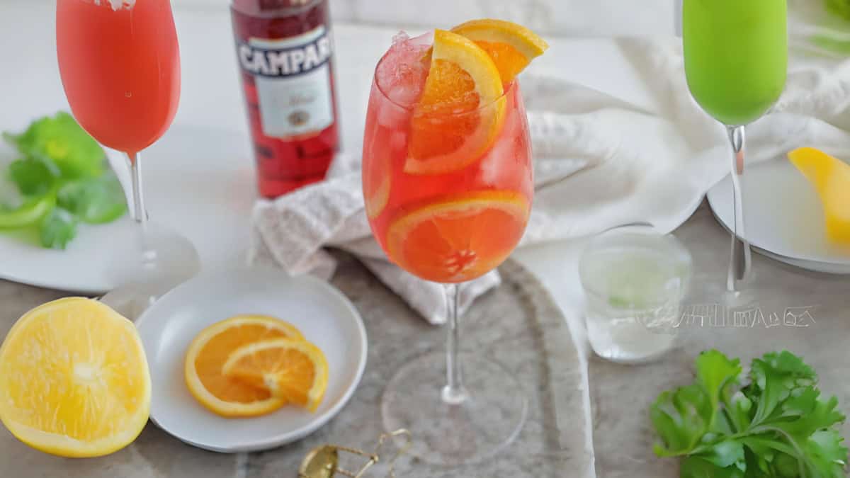 campari spritz in a wine glass garnished with fresh orange slices.