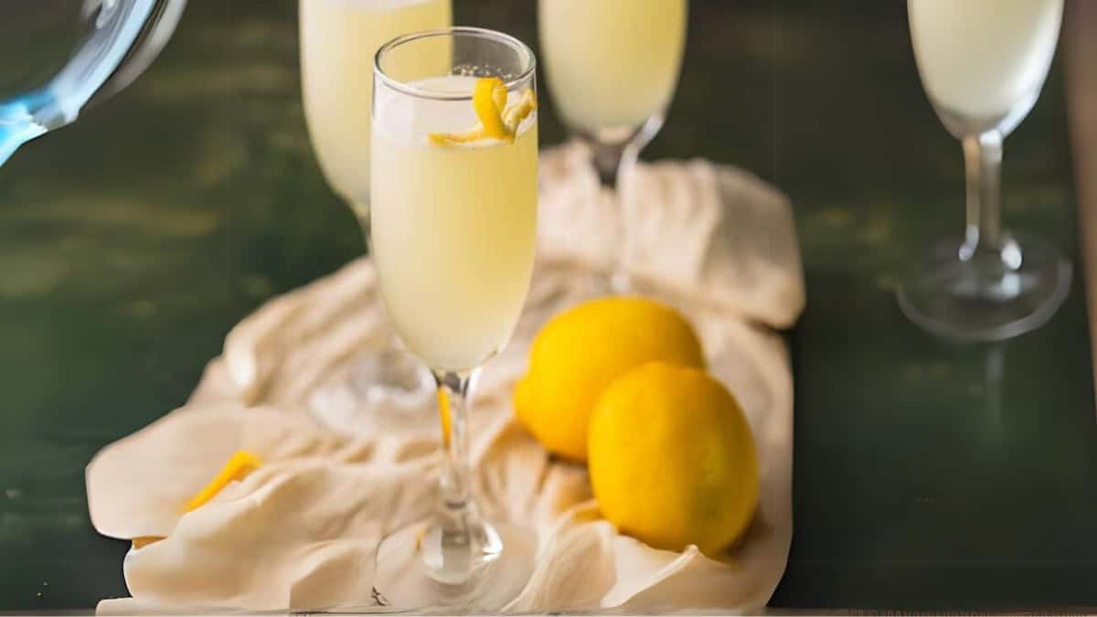 lemon cocktail in three champagne flutes with a lemon twist.