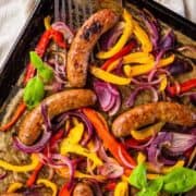 sausage, peppers and onions on a baking sheet.