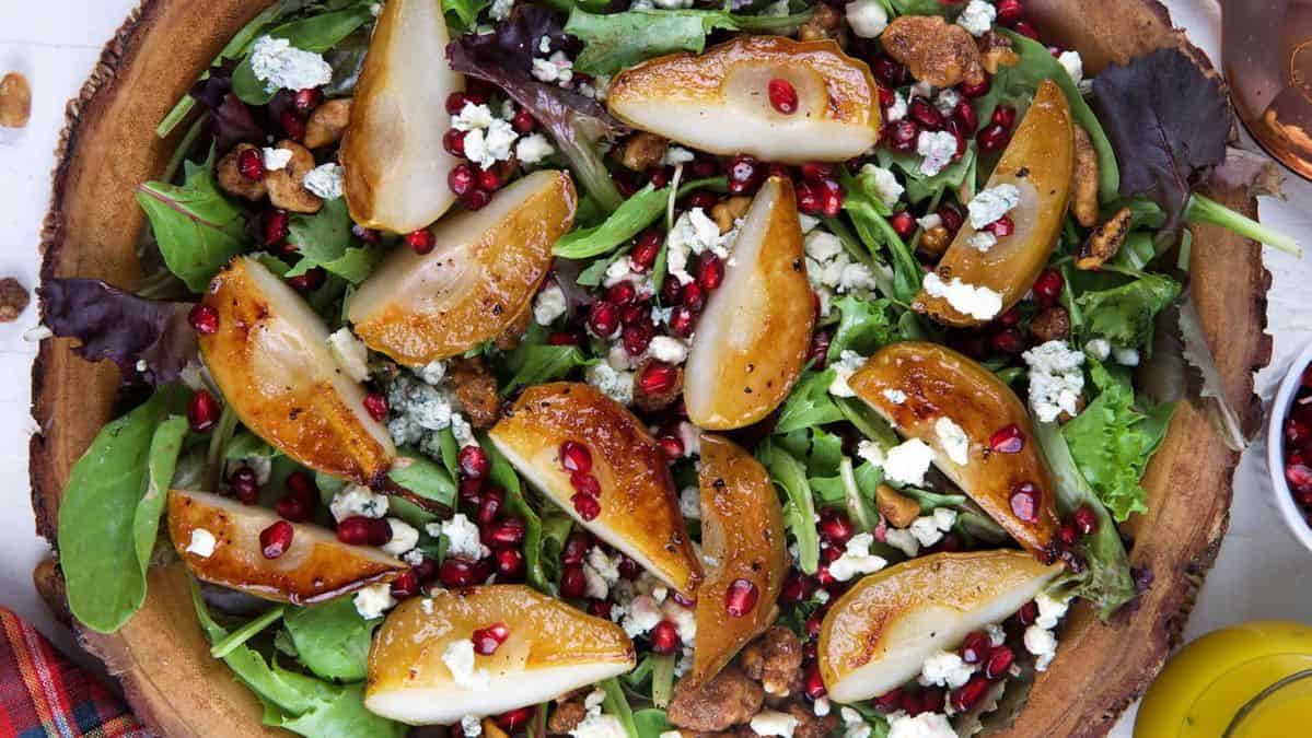 Salad top with roasted pears and pomegranate seeds.