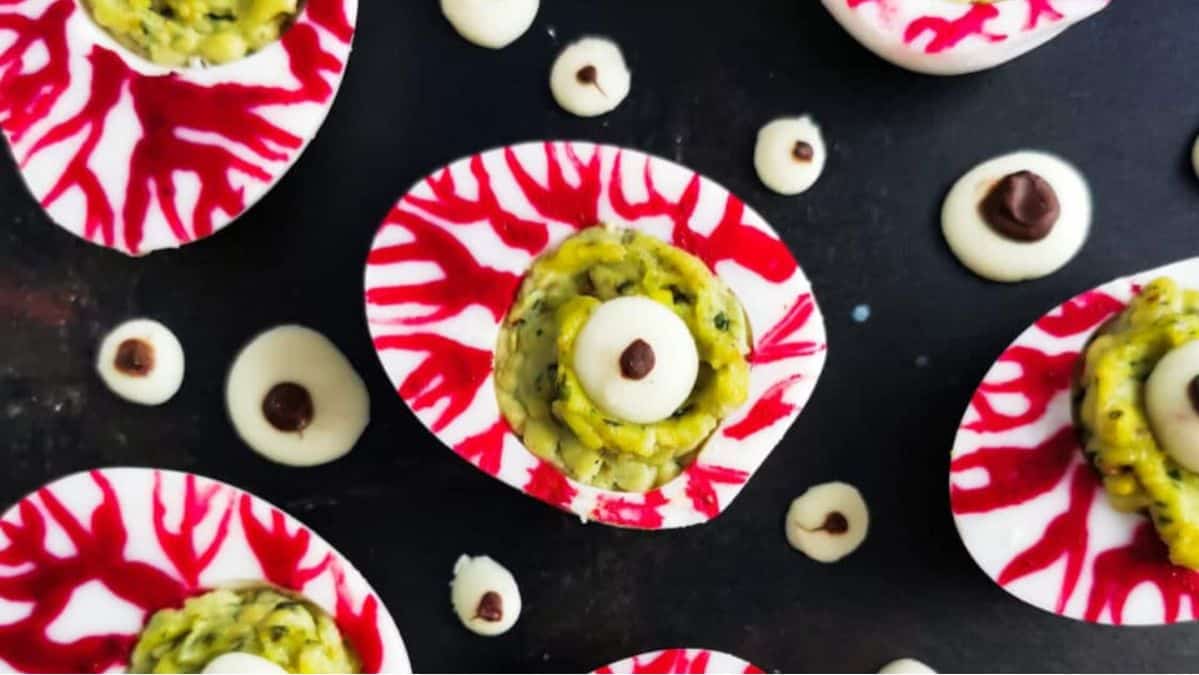 Hard boiled egg halves with red dye on them filled with guacamole and pretend eyes.