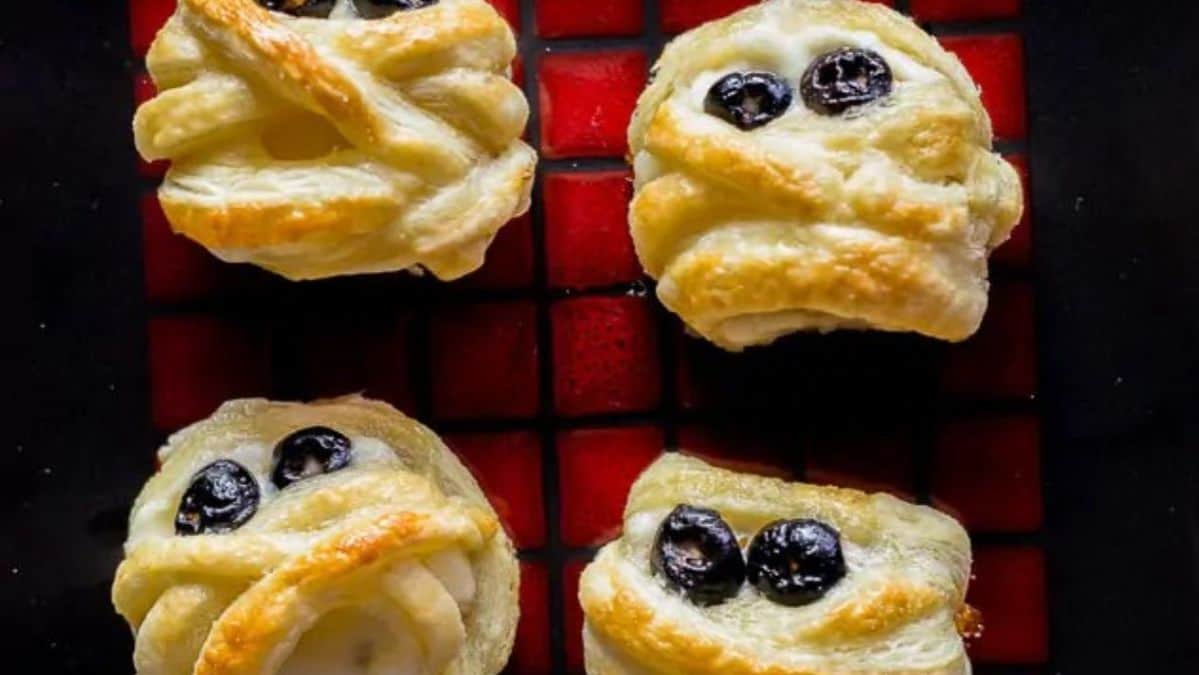 Puff pastry wrapped cheese wheels with sliced olives to look like eyes.