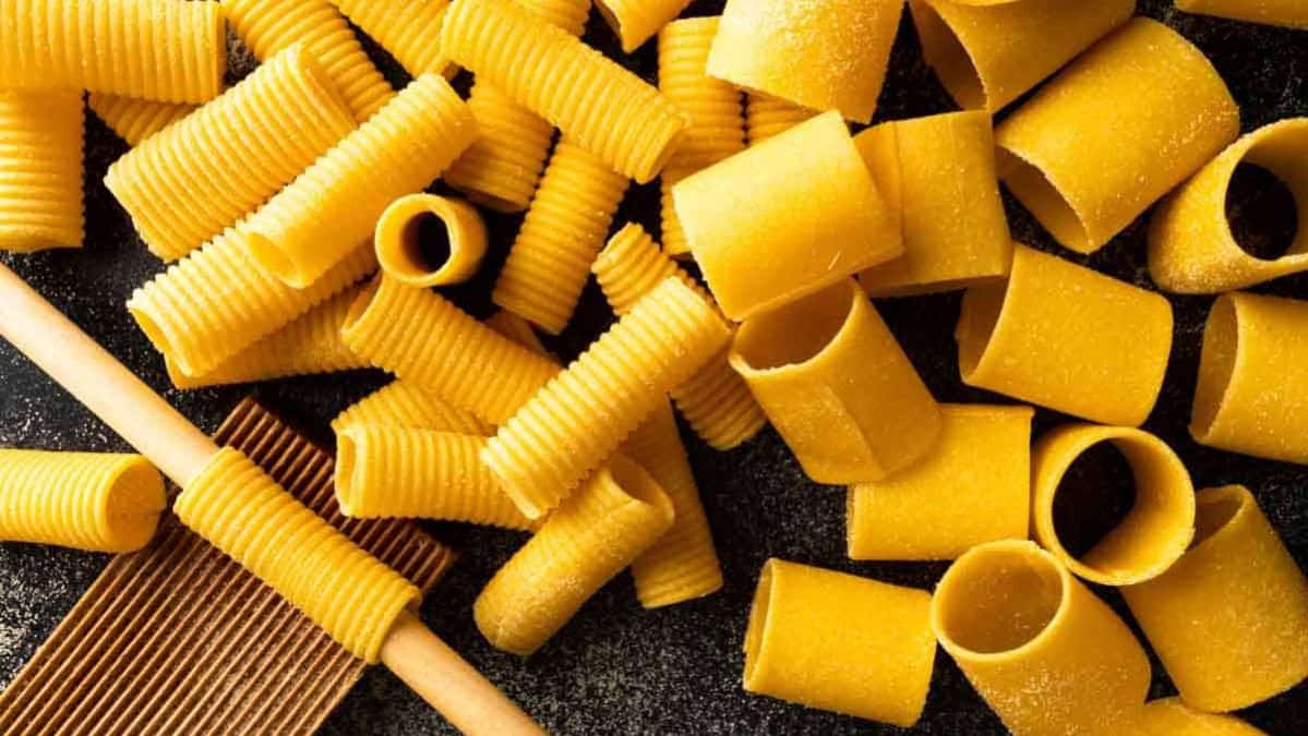 Handmade rigatoni and paccheri noodles on a table.