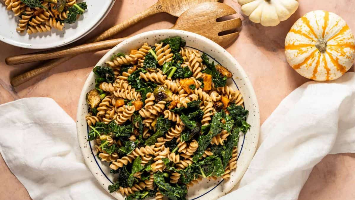 Pasta salad with greens and vegetables in it.