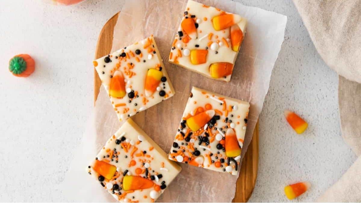 White fudge with candy, corn, and Halloween sprinkles cut on a tray.