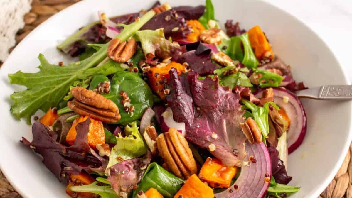 Salad with sweet potatoes, red onion, and pecans.